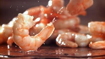 The shrimp falls on a wooden cutting board. Filmed on a high-speed camera at 1000 fps. High quality FullHD footage video