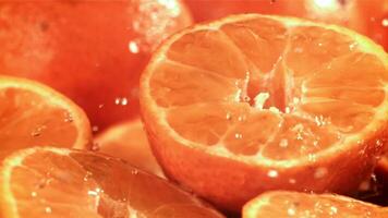 gotas de lluvia goteo en un Fresco Mandarina. filmado en un alta velocidad cámara a 1000 fps. alto calidad full HD imágenes video