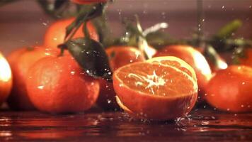 Slices of fresh tangerines fall on a wooden table. Filmed on a high-speed camera at 1000 fps. High quality FullHD footage video