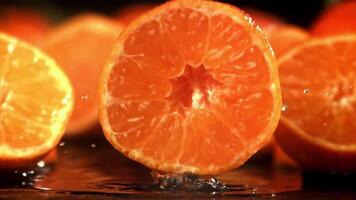 Half a tangerine falls on a wet table. Filmed on a high-speed camera at 1000 fps. High quality FullHD footage video