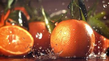 regndroppar droppa på en färsk mandarin. filmad på en hög hastighet kamera på 1000 fps. hög kvalitet full HD antal fot video