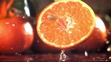 medio un Mandarina caídas en un mojado mesa. filmado en un alta velocidad cámara a 1000 fps. alto calidad full HD imágenes video