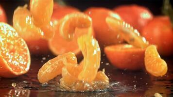 Scheiben von frisch Mandarinen fallen auf ein hölzern Tisch. gefilmt auf ein schnelle Geschwindigkeit Kamera beim 1000 fps. hoch Qualität fullhd Aufnahmen video