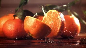 A tangerine breaks into two halves when it falls. Filmed on a high-speed camera at 1000 fps. High quality FullHD footage video