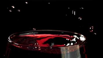 ein fallen Stürze in ein Glas von Wein. auf ein schwarz Hintergrund. gefilmt auf ein schnelle Geschwindigkeit Kamera beim 1000 fps. hoch Qualität fullhd Aufnahmen video