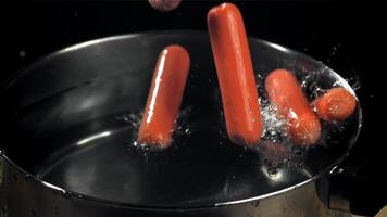 The sausages fall into a pot of water. Filmed on a high-speed camera at 1000 fps. High quality FullHD footage video