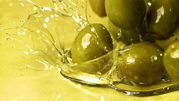 Fresh olives fall with splashes into the oil. Filmed on a high-speed camera at 1000 fps. High quality FullHD footage video