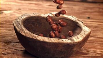 Hazelnuts fall into a wooden bowl. Filmed on a high-speed camera at 1000 fps. High quality FullHD footage video