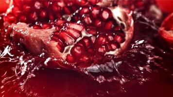 Part of the pomegranate falls into the juice with splashes. Filmed on a high-speed camera at 1000 fps. High quality FullHD footage video