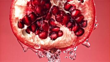 Splashed water pours onto fresh pomegranates. Filmed on a high-speed camera at 1000 fps. High quality FullHD footage video