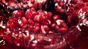 Part of the pomegranate falls into the juice with splashes. Filmed on a high-speed camera at 1000 fps. High quality FullHD footage video