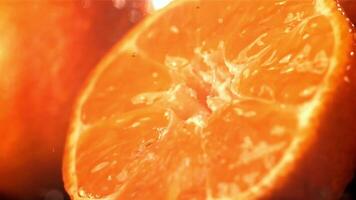 gocce di pioggia gocciolare su un' fresco mandarino. girato su un' alta velocità telecamera a 1000 fps. alto qualità FullHD metraggio video