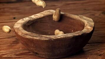 Peanuts fall into a wooden bowl. Filmed on a high-speed camera at 1000 fps. High quality FullHD footage video