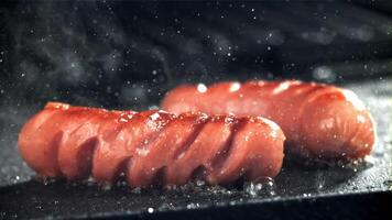 Sausages are fried with splashes in a pan. Filmed on a high-speed camera at 1000 fps. High quality FullHD footage video