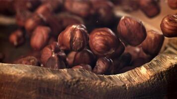 Hazelnuts fall into a wooden bowl. Filmed on a high-speed camera at 1000 fps. High quality FullHD footage video