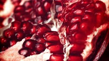 Splashed water pours onto fresh pomegranates. Filmed on a high-speed camera at 1000 fps. High quality FullHD footage video