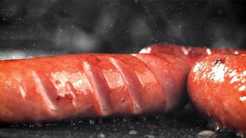 Sausages are fried with splashes in a pan. Filmed on a high-speed camera at 1000 fps. High quality FullHD footage video