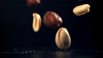 A variety of nuts fall on the table. Filmed on a high-speed camera at 1000 fps. High quality FullHD footage video