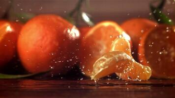 Slices of fresh tangerines fall on a wooden table. Filmed on a high-speed camera at 1000 fps. High quality FullHD footage video