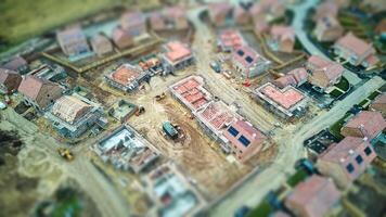 Aerial view of a residential construction site with unfinished houses and heavy machinery. photo