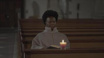 Jeune africain femme avec frisé cheveux prier à l'intérieur église video