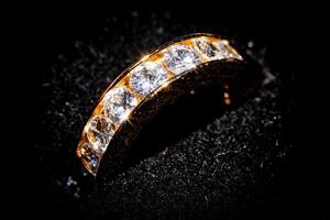 Elegant diamond ring on a black background with selective focus and a luxurious feel. photo