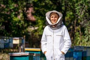 Handsome man working beekeeping with hive. Harvesting beeswax in sunny summer. photo