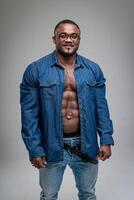 africano hombre vistiendo pantalones y desabrochado camisa. bueno abdominales de un de piel oscura hombre. muscular hombre en el blanco fondo foto