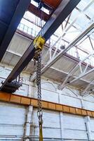 Metallic industrial hook for lifting heavy thing in the factory. Crane chain and hook inside factory background. photo