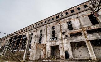 Abandoned building. Old factory ruin and broken windows photo