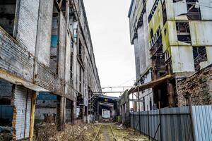 Old factory ruin and broken windows. Industrial building for demolition photo