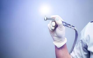 estomatológico instrumento en dentistas clínica. médico toma mano perforar. dentista herramientas foto