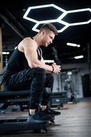 cansado hermoso hombre tener un descanso después ejercicio. el entrenador trabajando fuera en el gimnasia. foto