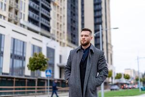 Confident handsome man looking through the urban city. Succesfull businessman walking on the street. photo