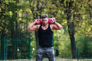 Handsome bodybuilder training outdoor. Fitness young man working out outdoor. photo