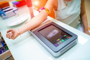 Young woman finding veins with vein scanner device for injection in a medical laboratory photo