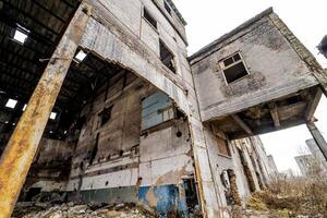 Abandoned building with debris in the city after the war. Broken house on ruin demolishing site after destruction. Close-up photo