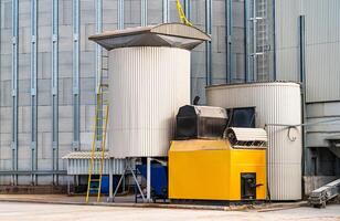 Industrial metallic factory processing. Steel agricultular warehouse. White cylindrical tank. photo