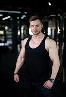 Handsome bodybuilder posing for camera. Fitness young male trainer. photo