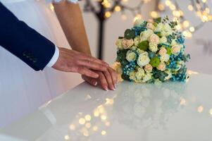 picture of man and woman holding hands over wedding flowers background. Marriage concept. photo