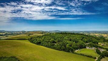 Scenic aerial view of lush green countryside with rolling hills and blue skies, perfect for backgrounds or nature themes. photo