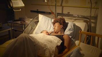 jong Afrikaanse moeder aan het liegen in ziekenhuis bed Holding pasgeboren baby na geboorte video