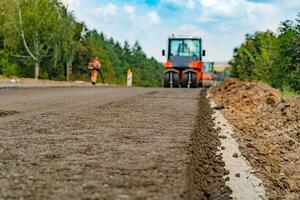 vibrating roller machines are compacting asphalt on the road. photo