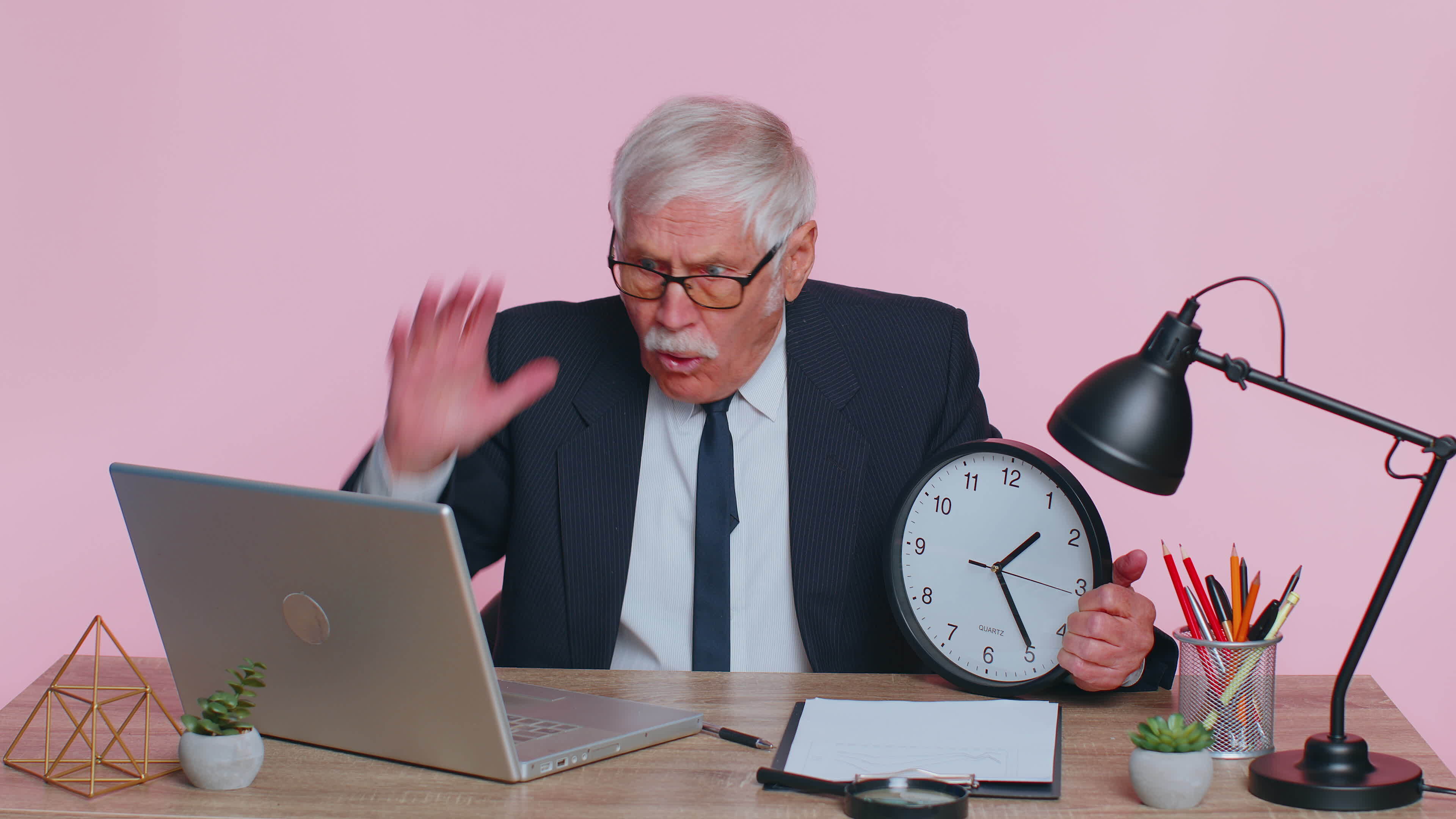 Senior businessman with anxiety checking time on clock, running late to