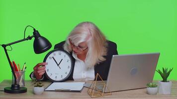 Senior businesswoman with anxiety check time on clock, running late to work being in delay deadline video