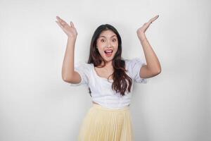 A smiling Asian woman, pointing to copy space above her, isolated by white background. photo