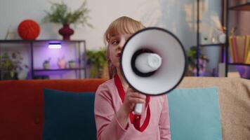 Child girl kid standing on sofa at home alone loudly shout in megaphone announces discounts sale video