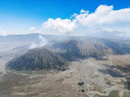 Aerial view of active volcano with crater in depth. Brown dirt around. clouds of smoke on volcano, Mount Bromo, Indonesia photo