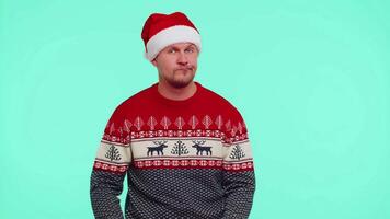 Confused man in Christmas sweater feeling embarrassed about ambiguous question having doubts no idea video