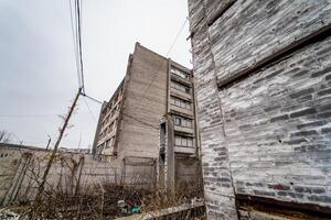 Old industrial building for demolition. Abandoned building exterior photo